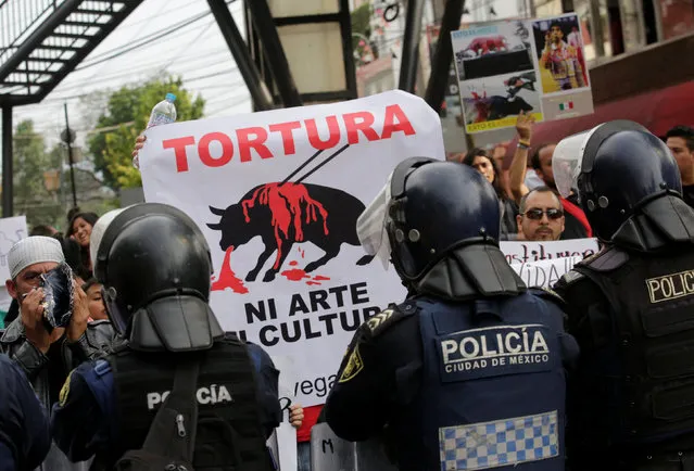 Protesters hold up a poster next to riot police during a demonstration against bullfights outside a bullring in Mexico City, Mexico May 29, 2016. The signs reads, “Torture: It is not art, it is not culture”. (Photo by Henry Romero/Reuters)