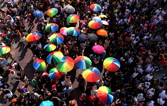 Aerial view of people holding umbrellas with rainbow colors while participating in the Pride March in Guadalajara, Jalisco State, Mexico, on June 15, 2024. (Photo by Ulises Ruiz/AFP Photo)