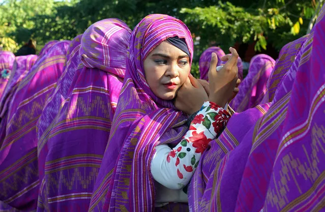 A woman adjusts her headscarf during a cultural and environmental themed parade in Bali, Indonesia, Thursday, June 2, 2016. (Photo by Firdia Lisnawati/AP Photo)