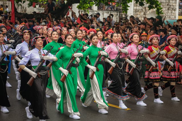 Vietnamese women from different ethnicities wearing their traditional dress carrying assault weapons parade on the street as Vietnam marks the 70th anniversary of the 1954 Dien Bien Phu battle on May 7, 2024 in Dien Bien Phu City, Dien Bien Province, Vietnam. More than 12,000 participants are set to take part in the 70th-anniversary ceremony of the Dien Bien Phu battle, a significant event in the First Indochina War, which will culminate in a grand parade on May 7 at Dien Bien Province's stadium, featuring the air force, fireworks force, and parade force. The Battle of Dien Bien Phu was one of the most major confrontations in the First Indochina War, fought between the Viet Minh Communist Revolutionaries and the French Union's French Far East Expeditionary Corps. Lasting from March 13 to May 7, 1954, this decisive battle ended with a victory for the Vietnamese side, effectively terminating the French presence in Indochina and leading to the signing of the Geneva Accords. (Photo by Linh Pham/Getty Images)