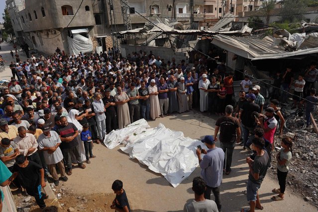 Mourners recite a prayer over the bodies of members of the Qadih family, before their burial in Khuzaa in the southern Gaza Strip, following an overnight Israeli strike that hit their house in Bani Suheila, reportedly killing two children, their father, uncle, paternal grandparents and severely injuring their mother, on July 21, 2024. Dozens have been killed since July 20 across Gaza, the civil defence agency said, including in strikes on homes in the central Nuseirat and Bureij areas and displaced people near southern Khan Yunis. (Photo by Bashar Taleb/AFP Photo)