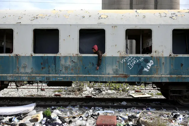 Habib, 22, from Algeria sits in an abandoned railway wagon used as a shelter by stranded migrants in the northern city of Thessaloniki, Greece, April 6, 2017. Habib  arrived at the Greek island of Rhodes three months ago and he reached the mainland after hiding in a truck on a passenger ferry to Athens. (Photo by Alexandros Avramidis/Reuters)