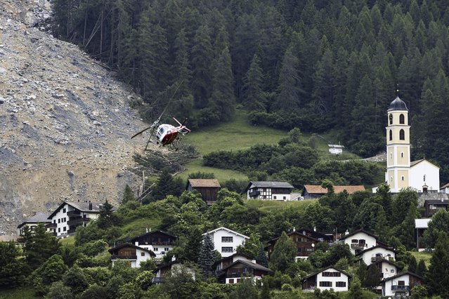 A helicopter flies over the rockfall “Brienzer Rutsch” above the village Brienz-Brinzauls in Switzerland, Friday, June 16, 2023. On Thursday night, a large part of the rock masses fell towards the village. The rock masses just missed the village and left behind a meter-high deposit on the main road near the school building. No one was injured since the village was evacuated on May 12. (Photo by Michael Buholzer/Keystone via AP Photo)