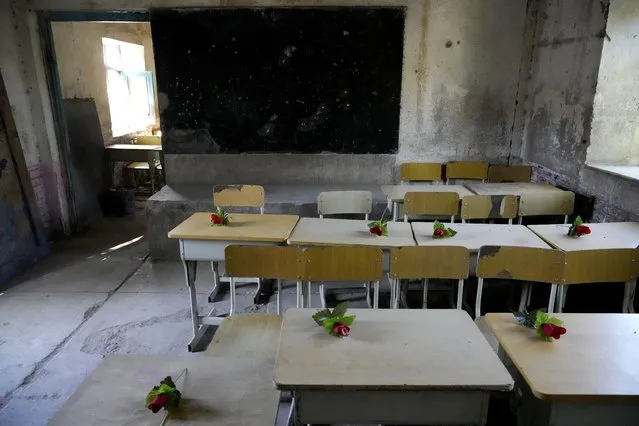 Roses are placed on empty desks as a tribute to students who were killed Tuesday's explosion in front of the Abdul Rahim Shaheed School, in Kabul, Afghanistan, Saturday, April 23, 2022. On Saturday, the Abdul Rahim Shaheed School, which was among the IS-K targets in the Tuesday attacks, re-opened. The school's principal handed each student a pen and a flower as they began classes on Saturday. (Photo by Ebrahim Noroozi/AP Photo)