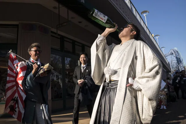 A man drinks a bottle of sake after attending a Coming of Age ceremony at the Toshimaen amusement park on January 13, 2020 in Tokyo, Japan. (Photo by Tomohiro Ohsumi/Getty Images)