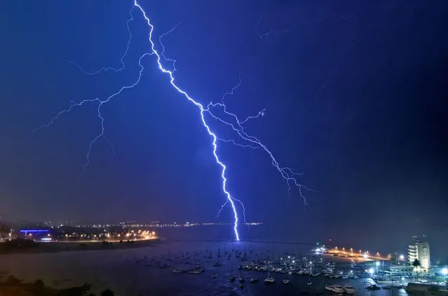 A lightning bolt strikes near the Uruguayan Yacht Club during a thunderstorm in Montevideo early on November 16, 2021. (Photo by Mariana Suarez/AFP Photo)