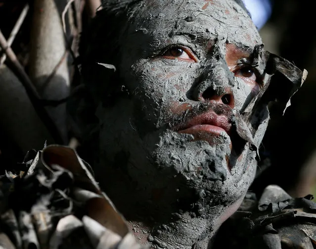 A villager, donning capes mostly of dried banana leaves and covered in mud, attends a mass in a bizarre annual ritual to venerate their patron saint, John the Baptist, Friday, June 24, 2016 at Bibiclat, Aliaga township, Nueva Ecija province in northern Philippines. The “Taong Putik” or “mud people” festival in Bibiclat village dates back to the Japanese occupation of the Philippines in the 1940s. Japanese troops gathered many of the male villagers in a Bibiclat church courtyard for execution by firing squad. (Photo by Bullit Marquez/AP Photo)