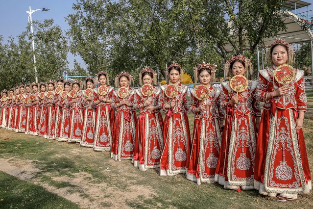 Brides in traditional Chinese costumes pose for photos during a group wedding ceremony in Yuncheng, in northern China's Shanxi province on September 22, 2024. (Photo by AFP Photo/China Stringer Network)