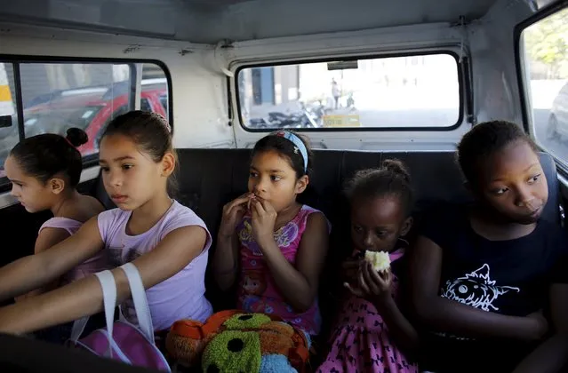 Young girls ride a van to their ballet lesson at the New Dreams dance studio, passing through the rough Luz neighborhood known to locals as Cracolandia (Crackland), in Sao Paulo, Brazil, August 14, 2015. (Photo by Nacho Doce/Reuters)