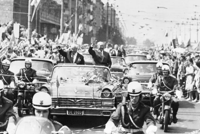 Soviet Premier Nikita Khrushchev, left, waves and rides in an open car, with Polish Party Leader Wladislaw Gomulka, through the streets of Warsaw, Poland, July 21, 1964. (Photo by AP Photo)