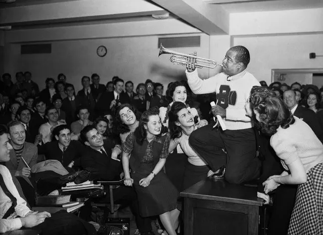 In this March 12, 1941, file photo, Louis Armstrong, wearing a Brooklyn College sweater, performs on the campus in New York as the school honored him with the degree “Doctor of Swing”. (Photo by AP Photo)