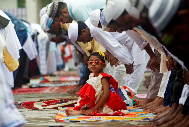 A girl looks on as muslims offer prayers during the Eid al-Adha festival in Agartala, India September 2, 2017. (Photo by Jayanta Dey/Reuters)
