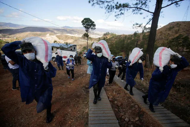 Soldiers carry bags of groceries to be delivered to residents in Los Pinos neighborhood, as part of the measures against the spread of the coronavirus disease (COVID-19), in Tegucigalpa, Honduras on March 25, 2020. (Photo by Jorge Cabrera/Reuters)