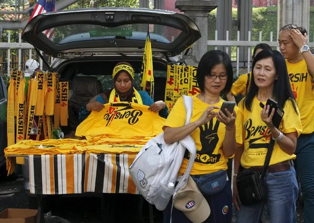 A shopkeeper sells pro-democracy group “Bersih” (Clean) merchandise from the back of her car at the Kuala Lumpur and Selangor Chinese Assembly Hall in Malaysia's capital city of Kuala Lumpur August 29, 2015. (Photo by Edgar Su/Reuters)