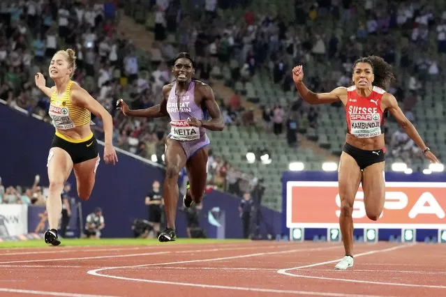 Gold medalist Gina Lueckenkemper, of Germany, bronze medalist Daryll Neita, of Great Britain, and silver medalist Mujinga Kambundji, of Switzerland, from left to right, cross the finish line the Women's 100 meters during the athletics competition in the Olympic Stadium at the European Championships in Munich, Germany, Tuesday, August 16, 2022. (Photo by Martin Meissner/AP Photo)