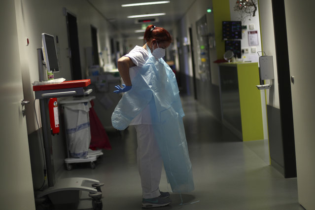 In this Wednesday, April 29, 2020 photo a nurse puts on protective gear at the start of a shift at the intensive care units of the hospital in Muehldorf am Inn, Germany. The whole hospital was converted for the treatment of corona patients. The new coronavirus causes mild or moderate symptoms for most people, but for some, especially older adults and people with existing health problems, it can cause more severe illness or death. (Photo by Matthias Schrader/AP Photo)