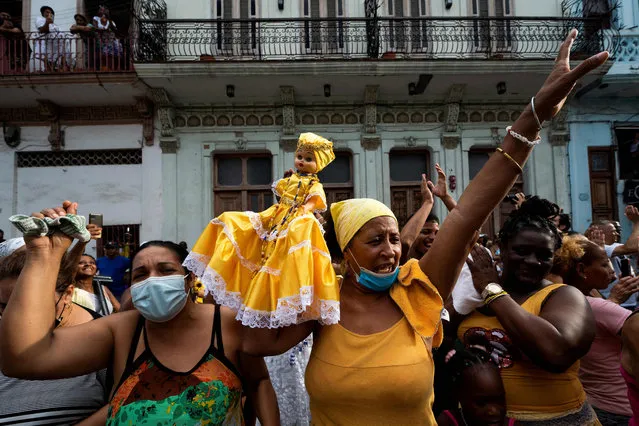 Followers of the Virgin of Charity - syncretized in the Yoruba religion with Ochun- take part in a procession in Havana during the Ochun Day celebrations in Cuba, on September 8, 2022. Thousands of Cubans, many dressed in yellow, accompanied “Cachita”, the Virgin of Caridad del Cobre, Cuba's patron saint, on Thursday in the traditional procession in Havana, which returned after two years of pandemic and confinement. But in that time also came the worst economic crisis in three decades, severe shortages, high prices, explosions in hotels and oil depots, long electricity blackouts and many cases of life-threatening dengue fever. (Photo by Yamil Lage/AFP Photo)