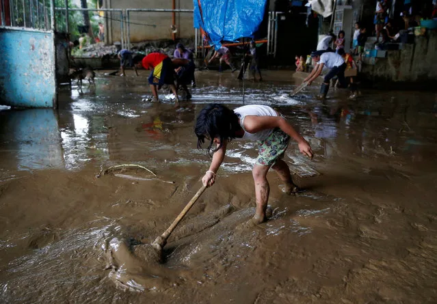 Residents remove mud that was brought by monsoon rains at an evacuation center swamped by flood in San Mateo, Rizal, Philippines, August 14, 2016. (Photo by Erik De Castro/Reuters)