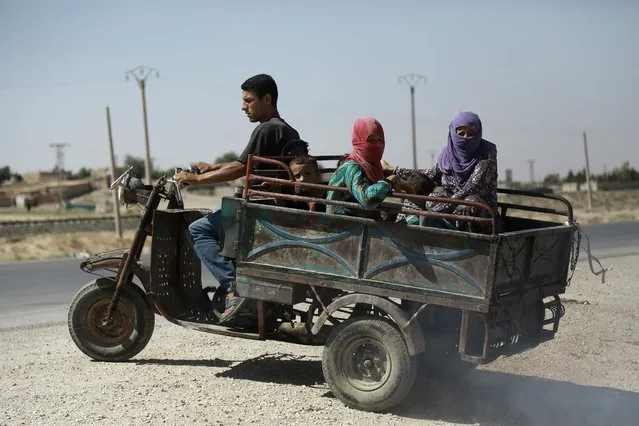 Syrian Kurdish civilians board vehicle as they flee reported shelling in the northeastern governorate of Hasakah, toward the city of Qameshli, on August 18, 2016. Syrian government aircraft bombed Kurdish positions in the divided northeastern city of Hasakeh, the first such strikes against a Kurdish-held area of Syria, the Syrian Observatory for Human Rights said. (Photo by Delil Souleiman/AFP Photo)
