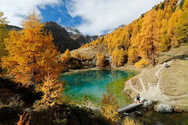 Hikers enjoy a warm autumn day near the Lac Bleu near Arolla in the Val d'Herens, Switzerland on Octoner 12, 2017. (Photo by Denis Balibouse/Reuters)