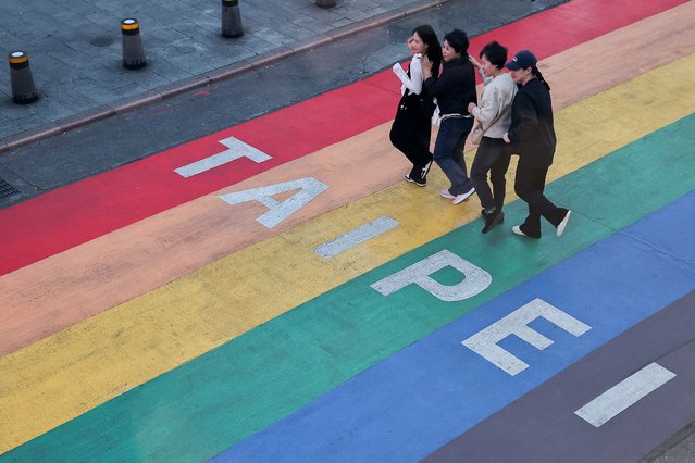 Tourists pose for photos at Ximending, a shopping district in Taipei, Taiwan on December 11, 2024. (Photo by Ann Wang/Reuters)