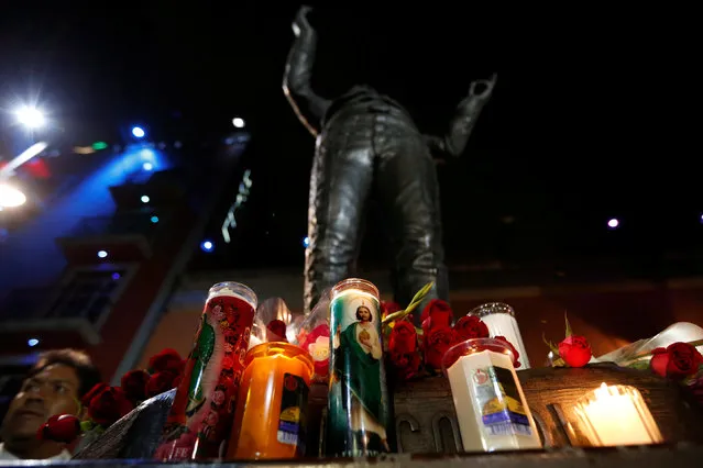 Candles are seen next to a statue of iconic Mexican singer and song writer Juan Gabriel after his death, in Plaza Garibaldi in Mexico City, Mexico August 28, 2016. (Photo by Carlos Jasso/Reuters)