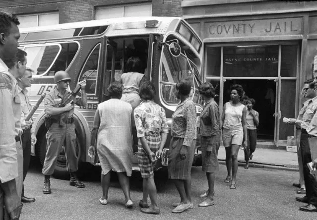 In this July 28, 1967 file photo, female prisoners arrested during the rioting in Detroit, board a bus at Wayne County Jail, watched by National Guardsmen for transfer to Eloise, a detention home for women on the edge of the city. Mass arrests of men, women and juveniles had taxed jail facilities in the city. (Photo by AP Photo)