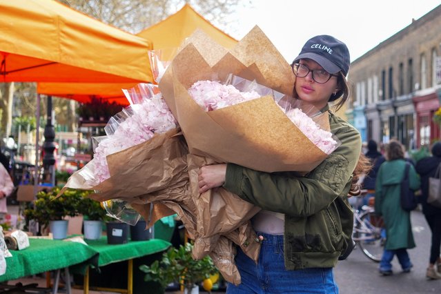 A person holds bouqets of flowers they bought at Columbia Road Flower Market on Mother's Day in London, Britain on March 30, 2025. (Photo by Maja Smiejkowska/Reuters)