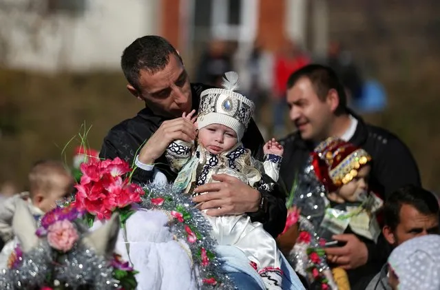 A Bulgarian Muslim man carries his son on a horse as they attend a ritual ahead of a mass circumcision ceremony in the village of Ribnovo, Bulgaria on November 13, 2022. (Photo by Spasiyana Sergieva/Reuters)