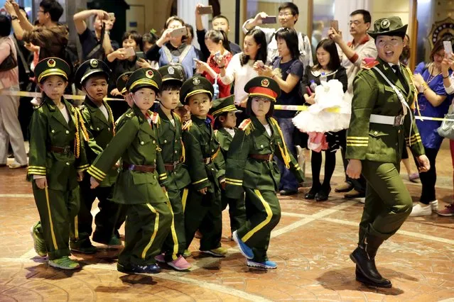 Children wearing uniforms march during a military parade game on China's National Day, at Beyou World, a centre where children can experience different kinds of professions, in Beijing, October 1, 2015. (Photo by Reuters/Stringer)