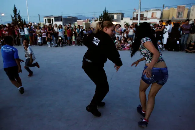 A police officer dances with a resident, an unconventional approach to connect the police with the community in rough neighbourhoods, as part of the “Tirando Barrio” (Marking territory) programme in Saltillo, Northern Mexico September 9, 2016. (Photo by Daniel Becerril/Reuters)