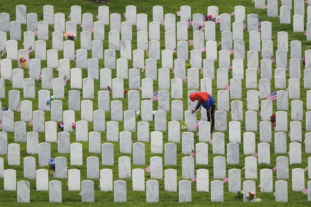 Richard Cross touches his grandmother's headstone while visiting Leavenworth National Cemetery on the eve of Memorial Day, Sunday, May 25, 2025, in Leavenworth, Kan. (Photo by Charlie Riedel/AP Photo)