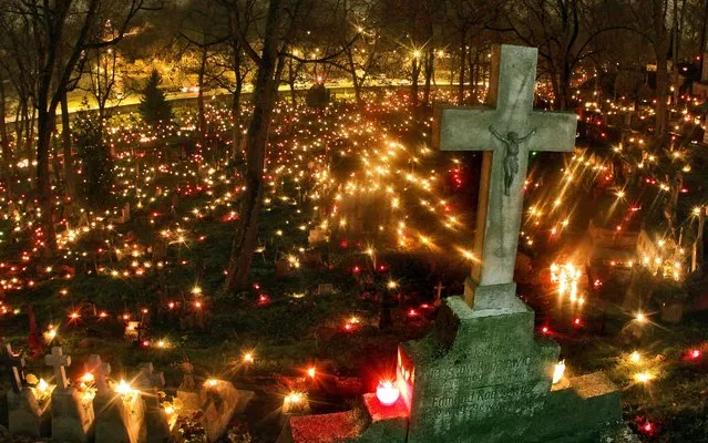 Candles are left on tombs to mark the occasion of All Saints' Day on the Rasos cemetery in Vilnius, Lithuania on November 1, 2014. In Lithuania, people visit cemeteries at this time across the country in memory of the deceased. (Photo by Petras Malukas/AFP Photo)