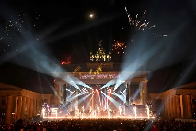 Fireworks explode over Berlin's landmark the Brandenburg Gate during a New Year's light and music show before midnight to welcome the year 2023, on January 1, 2023. (Photo by Tobias Schwarz/AFP Photo)