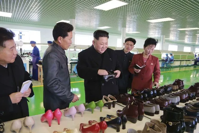 North Korean leader Kim Jong Un (C) inspects a pair of shoes during his visit to the Wonsan Shoes Factory in this undated photo released by North Korea's Korean Central News Agency (KCNA) in Pyongyang January 31, 2015. (Photo by Reuters/KCNA)