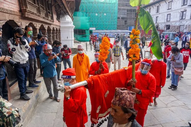 Nepali Hindu devotees wearing face shield and facial mask carry plants used for blessings as they attend the Fulpati procession marking the seventh day of the Dashain festival in Kathmandu, Nepal on October 23, 2020. Dashain festival is the longest and the most auspicious festival held in honour of the goddess Durga, commemorates the victory of the gods over the demons. (Photo by Sunil Pradhan/NurPhoto via Getty Images)
