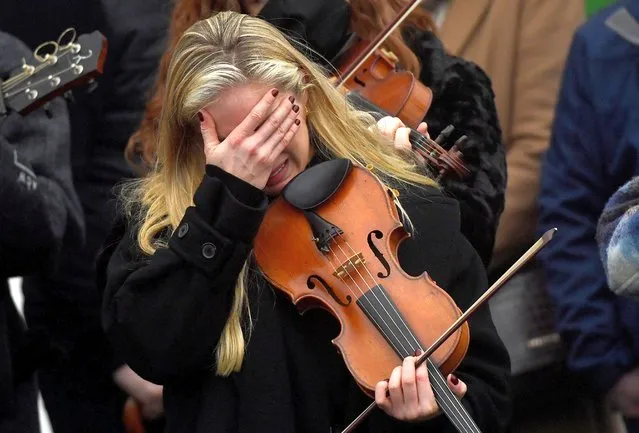A musician reacts during the funeral of late 23-year-old teacher, Ashling Murphy, who was murdered while out jogging, outside the St. Brigid's Church in Mountbolus near Tullamore, Ireland on January 18, 2022. (Photo by Clodagh Kilcoyne/Reuters)