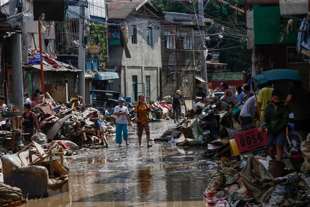 Residents return to recover muddied belongings from their homes at a community affected by flood in Marikina City, Metro Manila, Philippines on 13 November 2020. According to reports the death toll rose to at least 26 as Typhoon Vamco caused floods in Metro Manila, neighboring provinces and parts of the Bicol region after making landfall in the southern Luzon region. (Photo by Rolex Dela Pena/EPA/EFE)