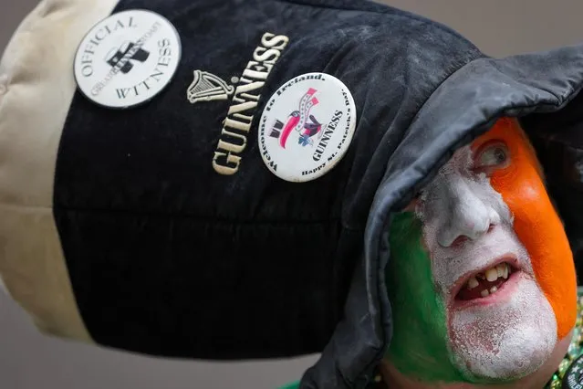 A person with their face painted with the flag of Ireland watches marchers during the annual Saint Patrick's Day Parade on 5th Avenue in Manhattan, New York City, U.S., March 17, 2023. (Photo by Andrew Kelly/Reuters)