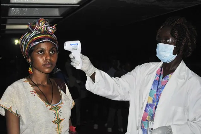 An Ethiopian health worker has her temperature taken upon arrival at Roberts airport outside Monrovia, Liberia, December 16, 2014. Scores of Ethiopian health workers arrived in Liberia on Tuesday to bolster the response to an Ebola outbreak that the government says it wants to stamp out before Christmas. (Photo by James Giahyue/Reuters)