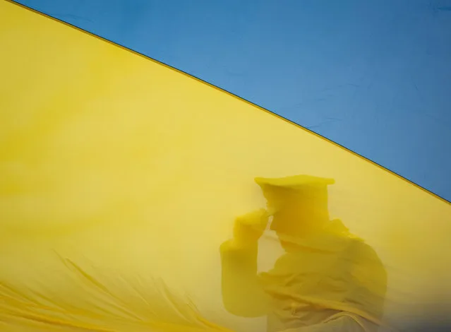 A member of the Honour Guard prepares to a rising ceremony of the Ukraine's national flag during a ceremony to mark the first anniversary of liberation the town of Bucha, as Russia's invasion of Ukraine continues, outside Kyiv, Ukraine on March 31, 2023. (Photo by Gleb Garanich/Reuters)