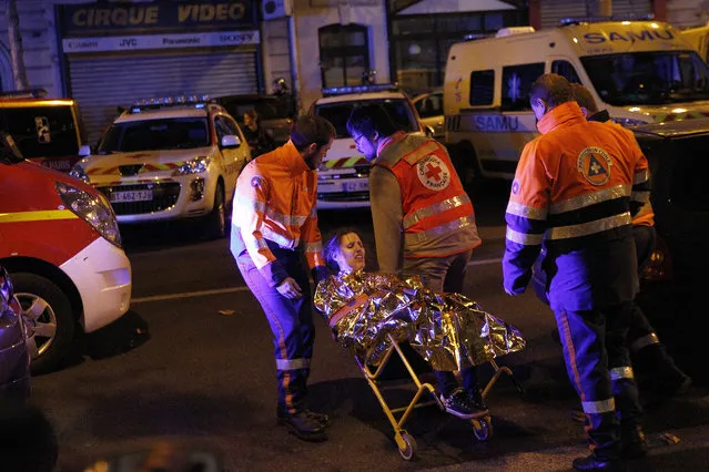 Medics evacuate an injured woman on Boulevard des Filles du Calvaire, close to the Bataclan theater, early on November 14, 2015 in Paris, France. According to reports, at least 149 people were killed in a series of bombings and shootings across Paris, including during a soccer game at the Stade de France and a concert at the Bataclan theater. (Photo by Thierry Chesnot/Getty Images)