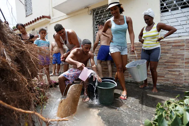 People collect water from a broken tube after Hurricane Irma caused flooding and a blackout in Havana, Cuba, September 11, 2017. (Photo by Reuters/Stringer)