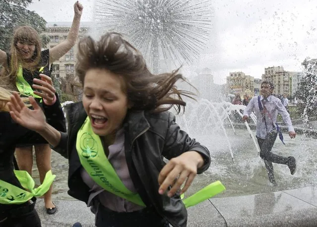 Secondary school graduates play in a fountain as they celebrate the last day of school in Kiev May 24, 2013. Students across Ukraine celebrated the end of the academic year on Friday, traditionally called the “last bell”. (Photo by Gleb Garanich/Reuters)