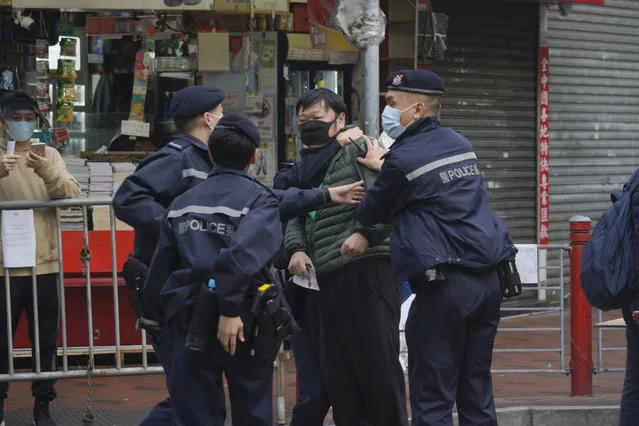 A man is detained after confronting a police officer as he wants to enter the closed area in Jordan area of Hong Kong, Saturday, January 23, 2021. Authorities said in a statement Saturday that an area comprising 16 buildings in Yau Tsim Mong district will be locked down until all residents have been tested. Residents will not be allowed to leave their homes until they have received their test results to prevent cross-infection. (Photo by Kin Cheung/AP Photo)