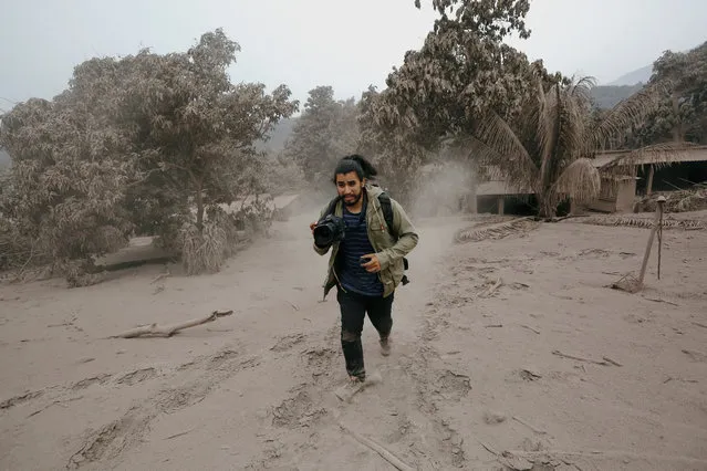 A photographer runs away from a new pyroclastic flow spewed by the Fuego volcano in the community of San Miguel Los Lotes in Escuintla, Guatemala on June 4, 2018. (Photo by Luis Echeverria/Reuters)