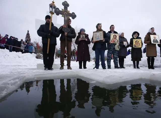 People attend an Orthodox religious service during a water blessing ceremony on Epiphany Day in the village of Velikoye, Yaroslavl region, January 18, 2015. (Photo by Sergei Karpukhin/Reuters)