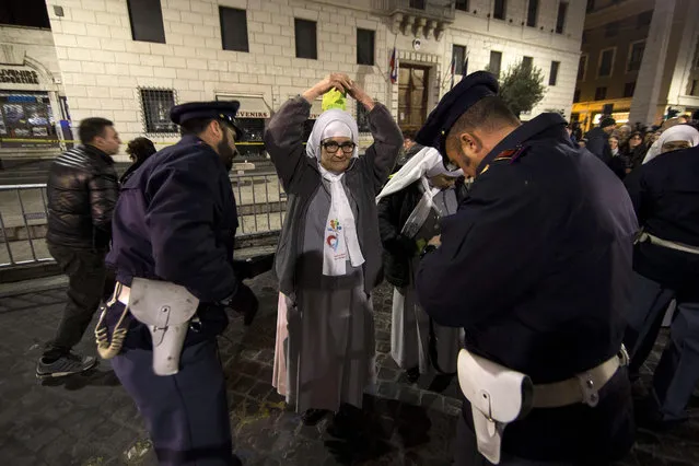 Italian Carabiniere checks a nun at the entrance of Saint Peter's square, Vatican City, 08 December 2015. Pope Francis is expected later in the day to open the Holy Door of St. Peter's Basilica for the start of the Jubilee of Mercy. (Photo by Massimo Percossi/EPA)
