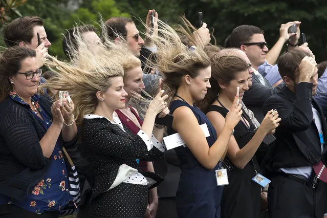 Wind created by Marine One taking off blows through the hair of visitors on the South Lawn as they watch the departure of US President Donald J. Trump, in Washington, DC, USA, 27 June 2018. Trump travels to Wisconsin, where he will stay overnight. (Photo by Michael Reynolds/EPA/EFE)