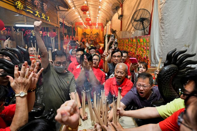 Devotees rush to plant the first joss stick at the stroke of midnight to usher in the Lunar New Year, the Year of the Snake in Leong Nam temple in Singapore on January 28, 2025. (Photo by Caroline Chia/Reuters)